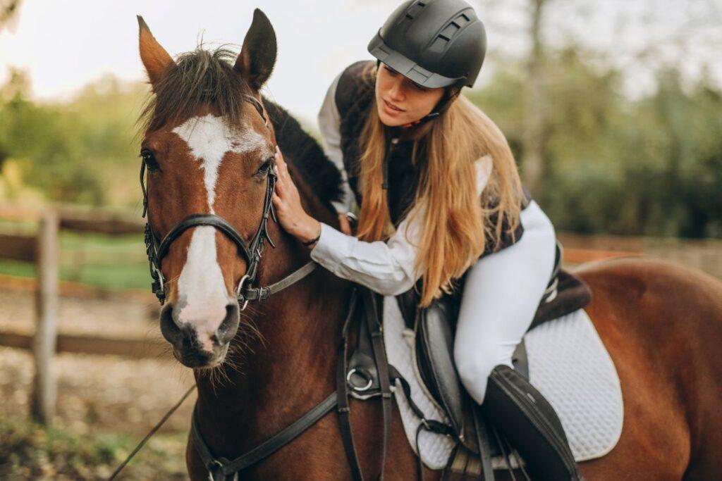 Young female rider bonding with her horse after training session – ideal match for equitation horses for sale.
